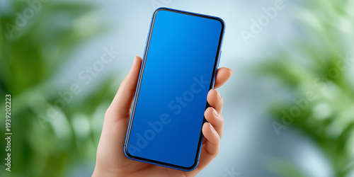 Hand holding blue smartphone with blank blue screen