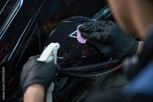 Schilderij op canvas Automobile detailing professional is decontaminating paint on car exterior