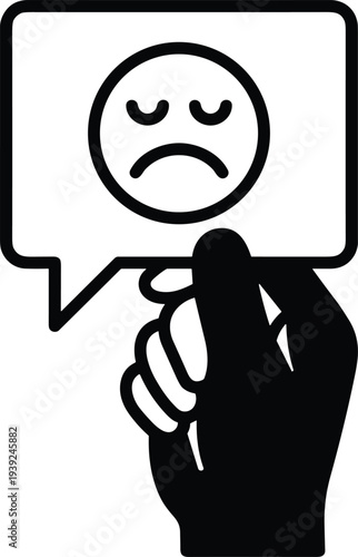 A hand holding a speech bubble with a sad face emoticon on a expressing dissatisfaction or unhappiness