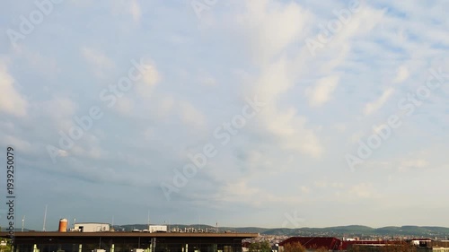 Factory building Pipe n white smoke at Vienna city Austria on Beaultiful clear Blue sky n fluffy cloud or cloudscape over house n green mountain, 4k Panoramic aerial view TimeLap of cityscape skyline