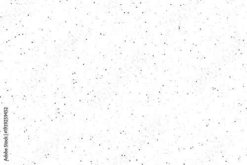 Scattered black particles create a fine uniform speckled pattern across a bright white field