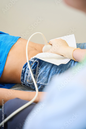 Adult woman receiving ultrasound scan in medical room