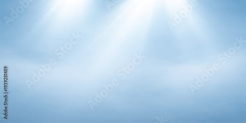 Bright sunlight with rays breaks through fluffy white clouds in a clear blue sky, creating a natural summer cloudscape with a bright abstract heaven view