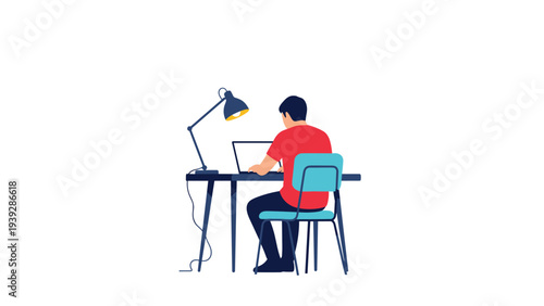 Man in a red shirt sitting at a desk with a laptop and a lamp working in a focused and productive environment at home or office.