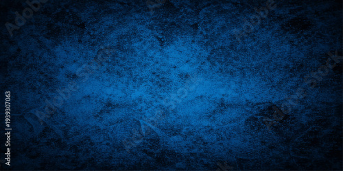 A dark blue grunge wall texture with a vintage aged paint design on a rough concrete surface creates a grungy antique backdrop