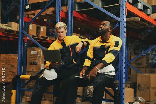 Obraz na plátně Two male workers responsible checking inventory warehouse are bored with their job both them feeling burnt out from their regular work feeling bored unhappy work sitting around with their minds blank