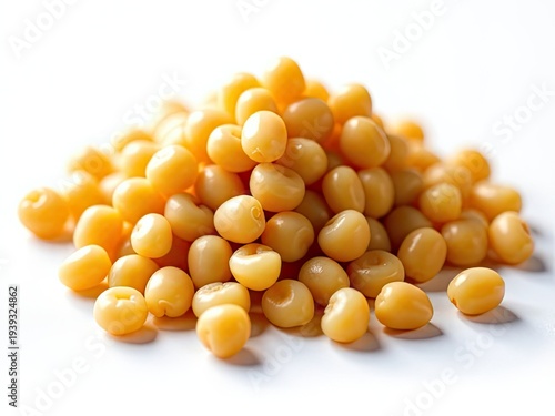 A pile of yellow beans sits on a white table, ready for use in cooking or as a decorative accent