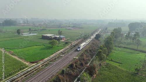 Aerial 4k shot of Vande Bharat Train Running in farm field in India