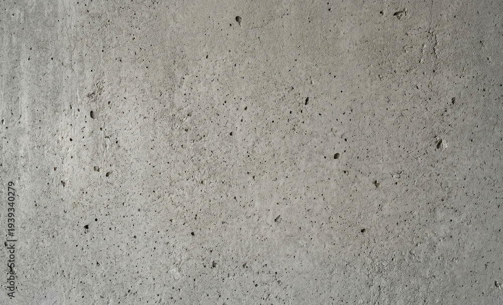 Fototapeta premium Concrete surface displays a textured pattern with visible imperfections and small black specks. The neutral gray color provides a versatile backdrop suitable for various designs.