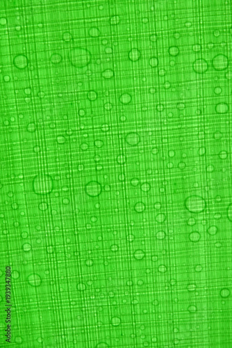 Vibrant green fabric with water droplets on textured surface