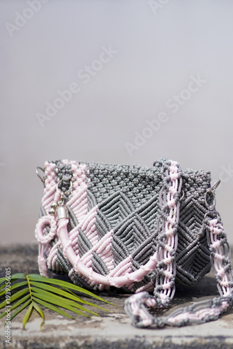 Handmade woven crossbody bag with palm leaf on stone surface
