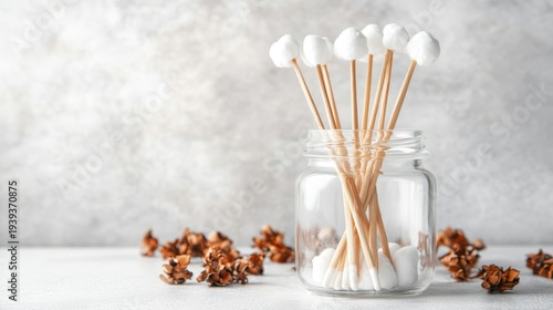 Neatly arranged organic cotton swabs with natural bamboo sticks in a clear glass jar