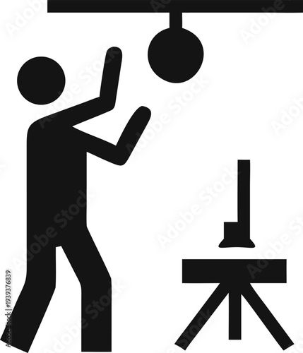 Production Technician Adjusting Spotlight Lighting Equipment on a Stand in a Studio Environment