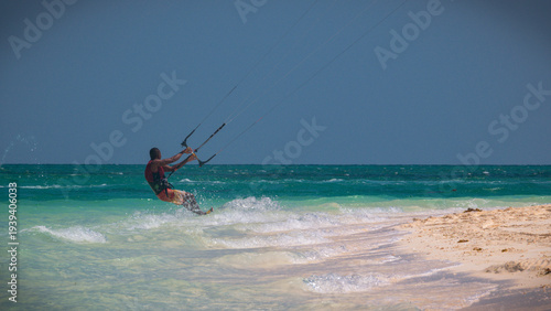Kitesurfing next to white sand beach and turquoise sea in Zanzibar