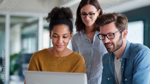Young multi-ethnic team collaborating while working on laptop in office  