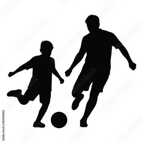 Father and son playing soccer together in silhouette