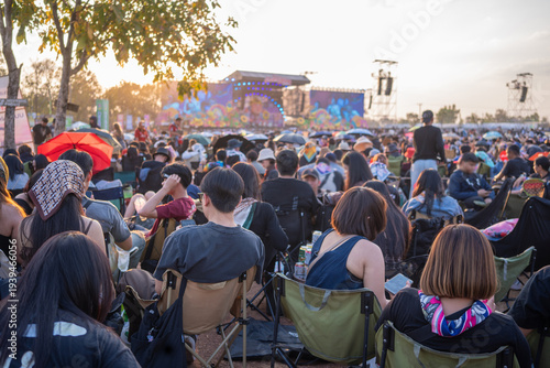 Large outdoor music festival crowd watching live concert at sunset stage