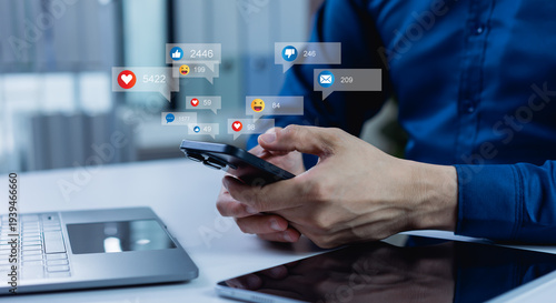 Foto A man uses a smartphone to interact with friends through chat, blog posts, livestream, and emoticon reactions on social media, driving engagement, likes, and digital marketing communication