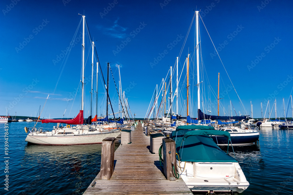 Fototapeta premium Sailboats moored in a marina under a clear blue sky
