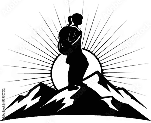 Silhouette of hiker atop mountain peak with sunburst