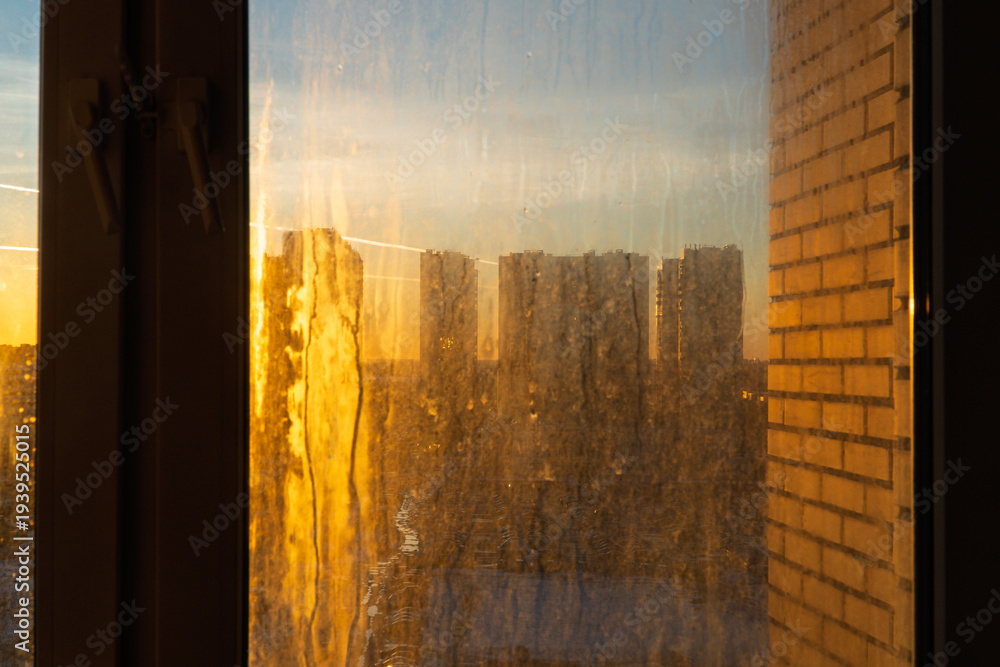 Naklejka premium Dirty and dusty dark window glass in the sunset. Abstract dirty window glass background. Window with very dirty and dusty glass in daylight in the sunset. Condensation on the fogged windows glass. 