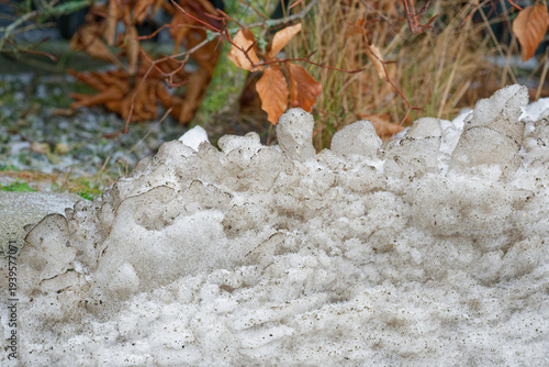 Obraz na plátně Dirty old grey snowbank left after roadside plowing.