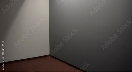 Empty modern room with spotlight on corner of gray and white walls