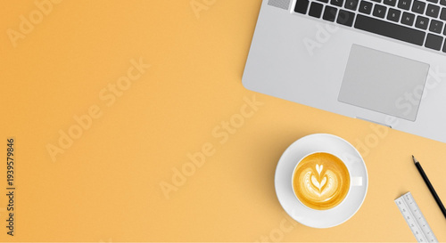 Modern workspace setup with laptop and coffee on yellow desk