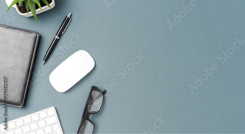 Modern workspace essentials on gray desk with computer mouse