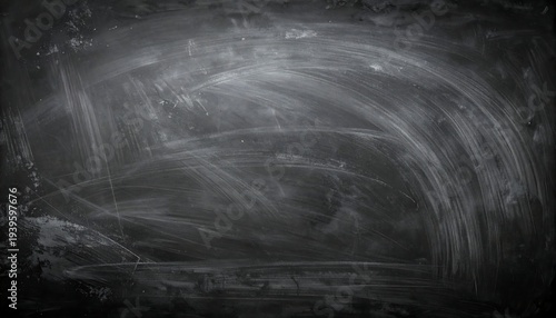 Wiped dark blackboard texture reveals streaky chalk residue in an arc formation, fading toward the lower frame