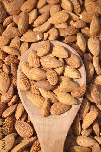 Dried almonds. Almond kernels lie in wooden spoon. Top view of nuts close-up. Advertising photography for marketplaces or online stores.