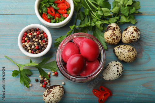 Pickled quail eggs and ingredients on blue wooden table, flat lay