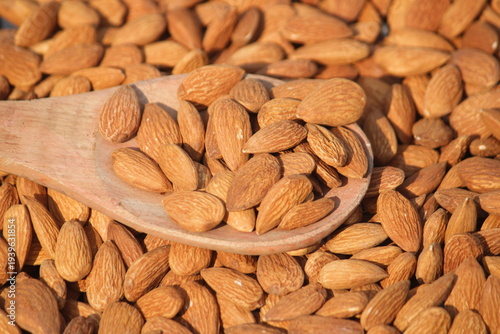 Dried almonds. Almond kernels lie in wooden spoon. Top view of nuts close-up. Advertising photography for marketplaces or online stores.