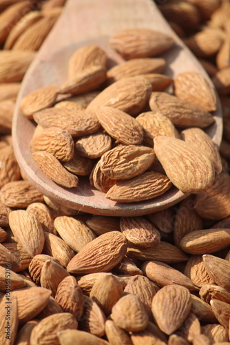 Dried almonds. Almond kernels lie in wooden spoon. Top view of nuts close-up. Advertising photography for marketplaces or online stores.