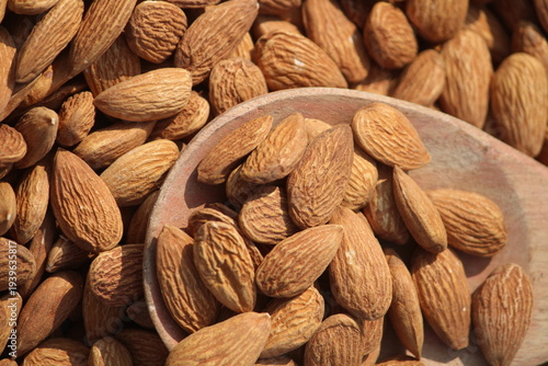 Dried almonds. Almond kernels lie in wooden spoon. Top view of nuts close-up. Advertising photography for marketplaces or online stores.