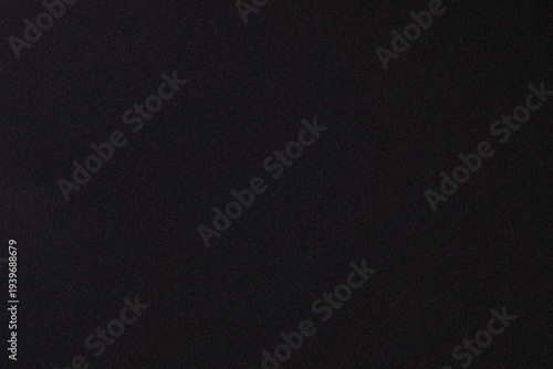 Photos A close-up view of a dark, textured fabric surface with subtle graininess