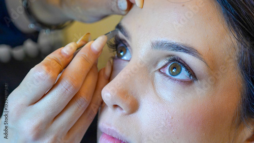 Vászonkép Eyelash styling and makeup touch-up for a bride on her wedding morning preparati