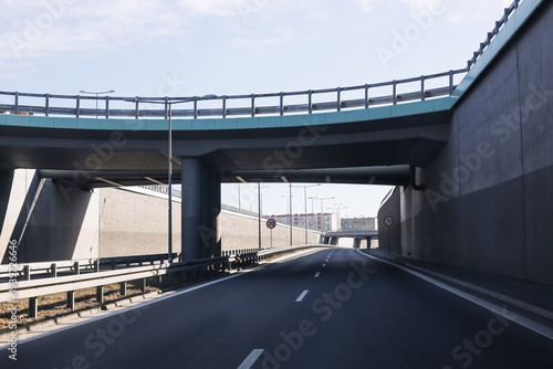 Photography Empty highway road passing under modern concrete overpass and bridge structure
