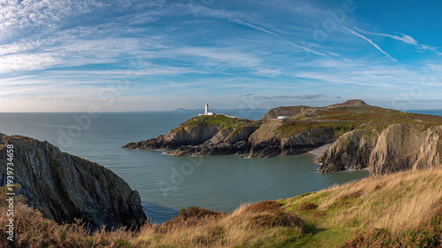 Coastal Lighthouse on Rocky Shoreline with Clear Sky