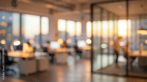 A blurred, out-of-focus background plate of a modern corporate office at sunset. Silhouettes of coworkers move subtly in a warm, bokeh-lit open space with city views. Ideal for business videos