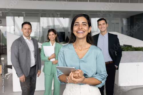 Valokuva Smiling young adult female team leader startup founder project coordinator stand