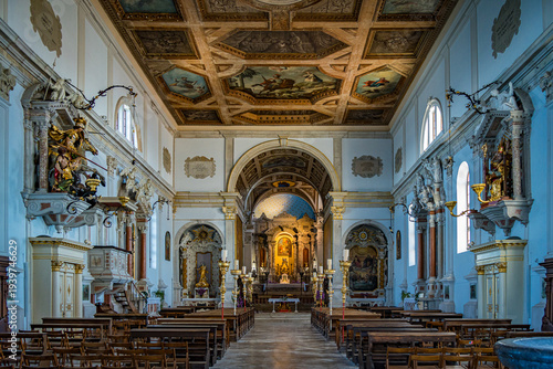 Grand church interior shows detailed architecture and religious art during the day with sunlight pouring through windows in Piran, Slovenia