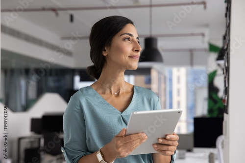 Canvas Print Confident Latina businesswoman planning project strategy using digital tablet in