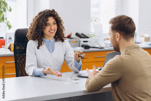 Tableau sur toile Optometrist consulting patient about contact lenses and vision correction option