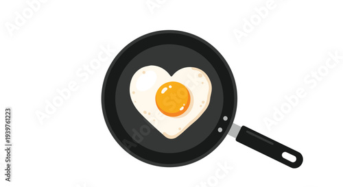 Top view of a heart shaped fried egg in a black frying pan for romantic breakfast or Valentines Day concept.