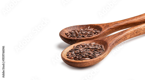 Two wooden spoons hold dark flax seeds
