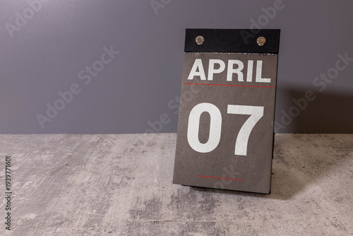 Photos Minimalist yellow wooden block perpetual date calendar displaying APRIL 07