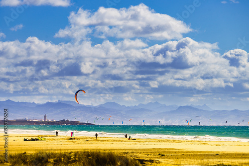 Kite surfers riding waves. Kiteboarding sport. Tarifa Spain.