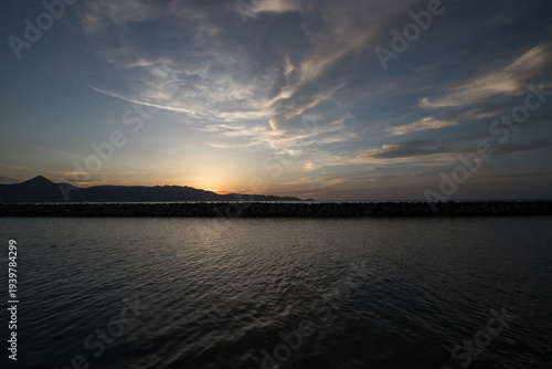 Beautiful synset behind mountains by the sea. Blue hour on an island. 
