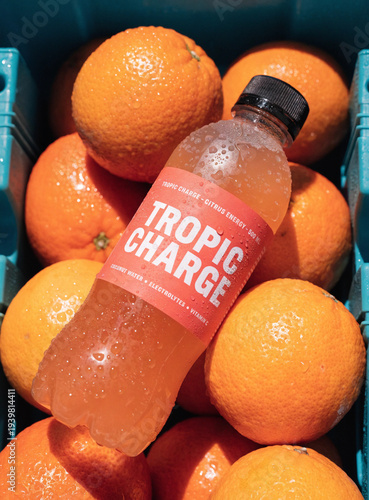 Orange soda bottle with fresh oranges, citrus drink concept
